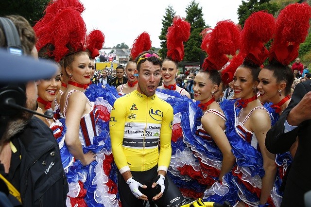 Mark Cavendish wordt voor de start van de tweede etappe vergezeld door een horde Frans uitgedoste dames.
